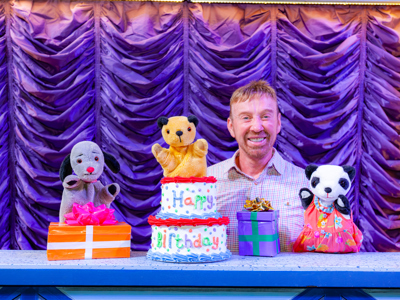 Photo of Richard Cadell, Sooty and Sweep with a birthday cake that says happy birthday