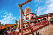 An image of a girl on an outdoor swing with blue skies 